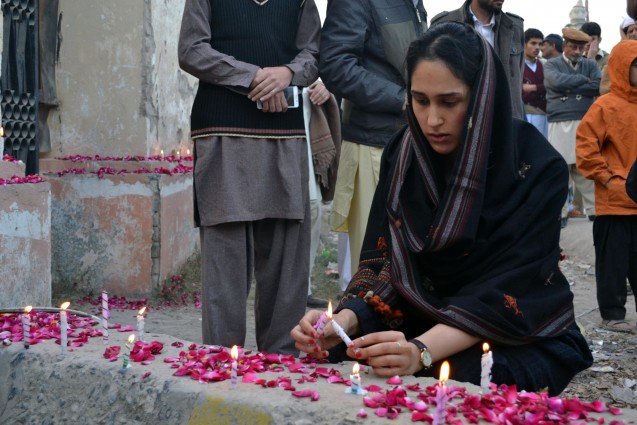 Lighting a candle in front of the school, where the massacre took place. Credit. Pukaar News
