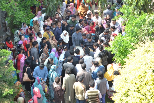 People crowd around a coffin of one of the deceased to show their respects.  Credit. Pukaar News