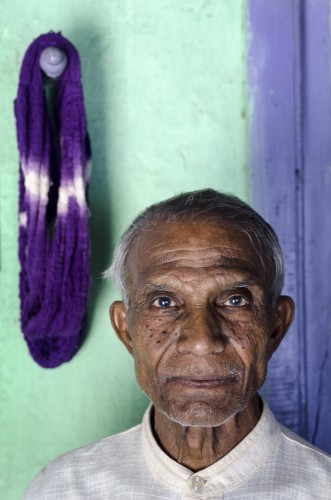 Premji Hari Manvar, who works from his home in the weaving community of Hamapur near Junagadh in Gujarat. The domestic manufacture of textiles from locally grown cotton is an age-old industry that supports most households in his village. They work with Udyog Bharti, a regional NGO which supports over 2,000 spinners and weavers making Khadi - a cloth made by hand from cotton, silk and/or wool - by supplying them with raw materials as well as marketing and distributing their finished products. From the exhibition India's Gateway: Gujarat, Mumbai & Britain. Photo by Tim Smith.